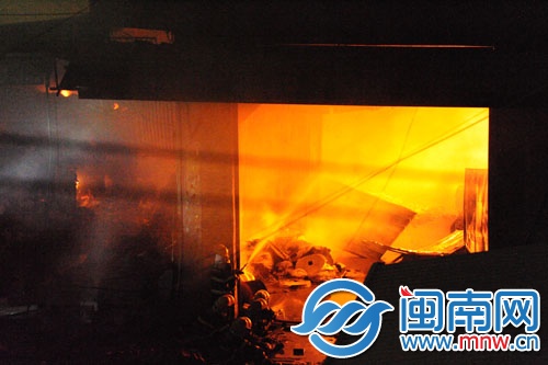 倉庫火勢很旺，消防員用水槍壓制