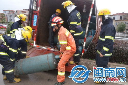 消防隊員將液化氣罐搬到另外一輛車上