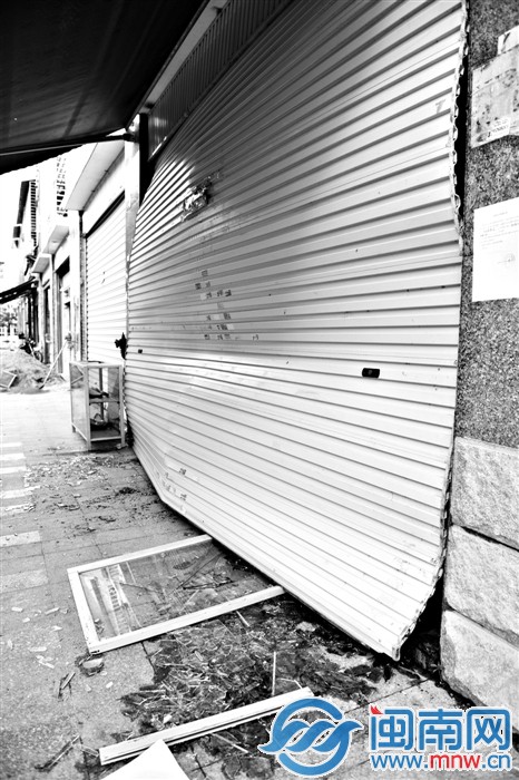 爆炸的沖擊波很大,卷簾門被損壞,門框和玻璃落一地