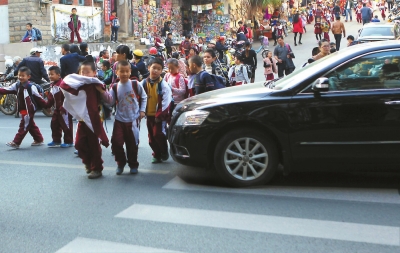 一輛汽車擠占了斑馬線,學生只能繞行