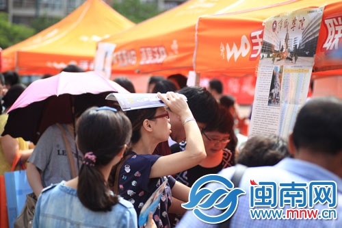 海都咨詢會現場,一名家長頂著烈日看學校信息